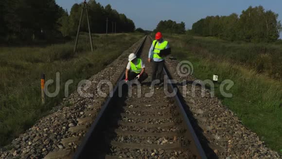 铁路工程师与助理人员一起检查铁路钢轨视频的预览图