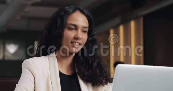 年轻的商务女性在现代办公室用笔记本电脑与老板打视频电话一位美丽的女人在镜头前讲话视频的预览图