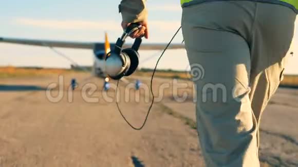 一个人拿着耳机走在跑道上后视视频的预览图