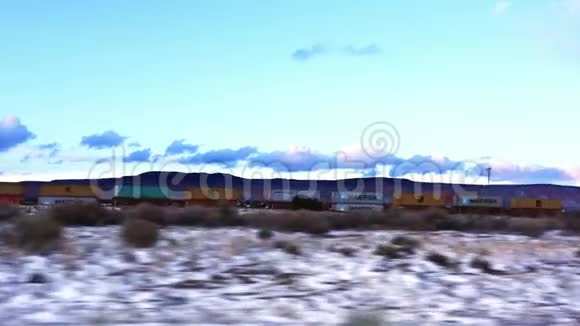跟在货运列车的后面载着油罐车的货物集装箱在冬天的雪漠上前进视频的预览图