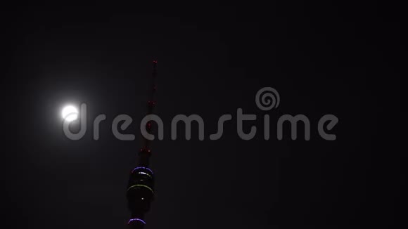 奥斯坦基诺塔用不同的颜色照明在满月旁边夜晚视频的预览图