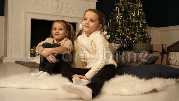 小女孩坐在地毯上看摄影师圣诞节的概念视频的预览图
