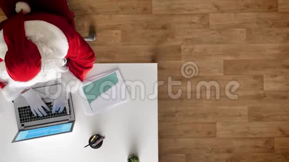 圣诞老人在办公室工作手提电脑打字鸟瞰上下射击多利射击视频的预览图
