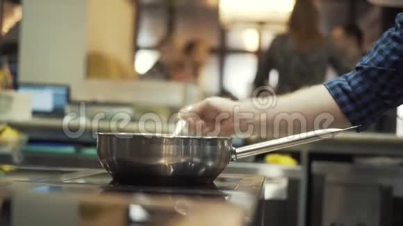厨师的特写他穿着一件蓝色格子衬衫在餐厅的厨房准备一些菜行动食物视频的预览图