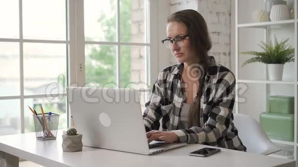 美丽的女人与投资笔记本电脑合作在家里的桌子上喝咖啡视频的预览图