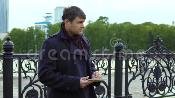 一个人在城市公园里使用平板电脑视频的预览图