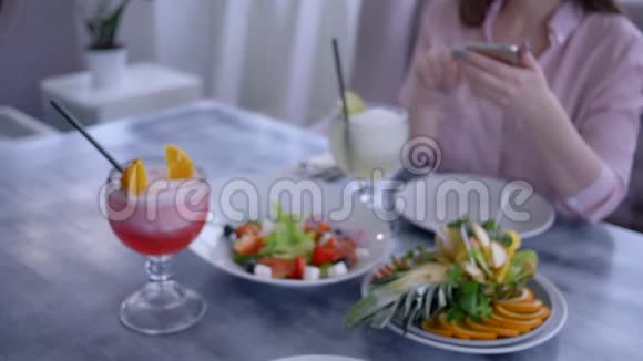 食物照片女孩手臂用手机拍摄健康早餐期间素食的照片社交媒体视频的预览图