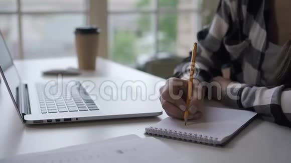女作家写投资笔记本在办公桌上工作笔记本电脑在家庭办公室视频的预览图