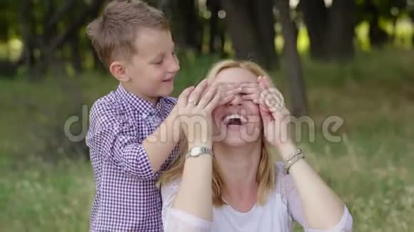 4母亲和儿子在公园里儿子遮住了母亲的眼睛视频的预览图