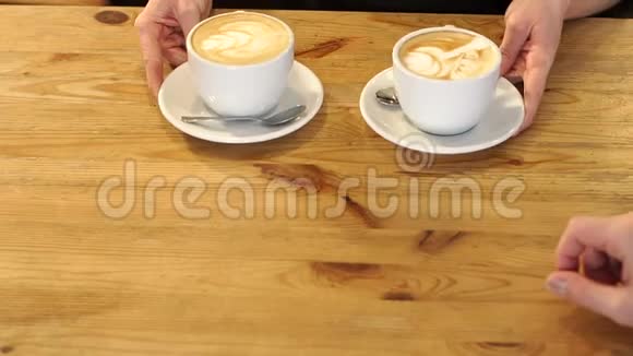 咖啡师拿着两杯芳香的卡布奇诺为咖啡店的客人服务视频的预览图