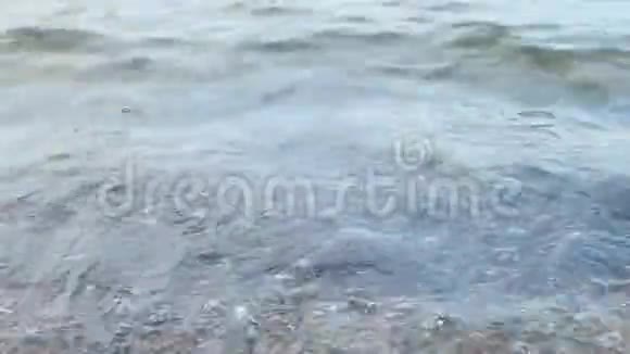 海浪拍打着海岸冲刷着岩石和贝壳视频的预览图