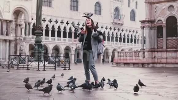 快乐兴奋迷人的旅游妇女鸽子坐在她的手臂和头在圣马可在威尼斯慢动作视频的预览图
