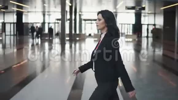 商务女性快速穿过一栋办公楼明亮的大厅视频的预览图