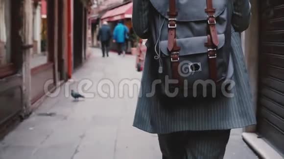镜头跟随时尚女商人穿着西装背包在威尼斯的老街上慢动作视频的预览图