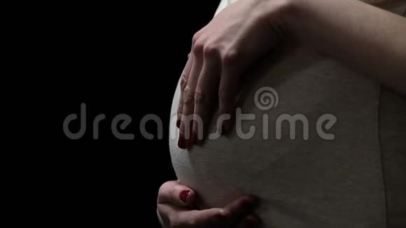 孕妇抚摸被隔离在黑色的腹部怀孕期间的健康风险视频的预览图