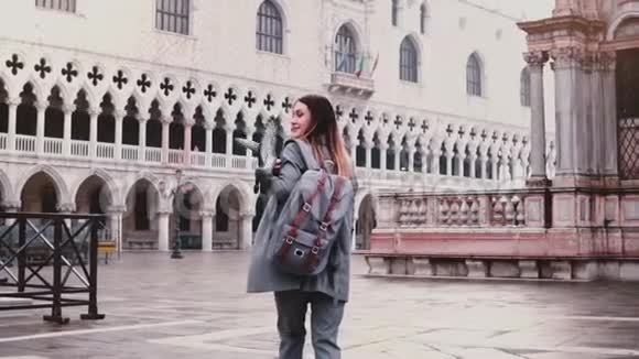 快乐美丽的白种人女游客在圣马可广场散步鸽子坐在威尼斯慢动作视频的预览图