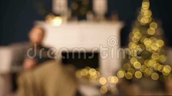 圣诞节时一个戴眼镜的男人在椅子上大声地在家看书圣诞内饰视频的预览图