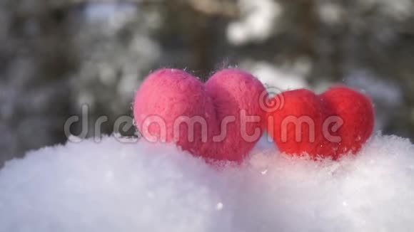 两颗情人节的羊毛心在冬天洁白的雪上慢动作视频的预览图