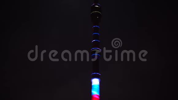 电视塔是由一个多颜色的照明接近满月夜晚视频的预览图