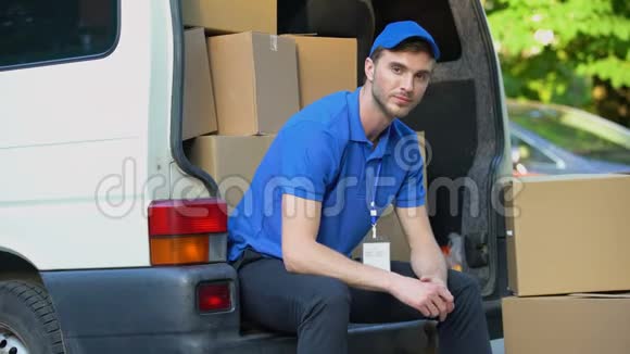 搬家公司的工人竖起大拇指坐在装满纸板箱的货车里视频的预览图