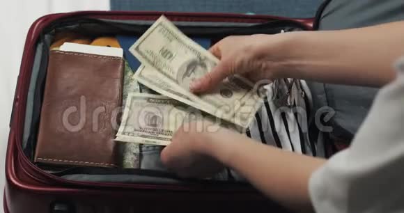 旅行的钱女人在手提箱背景上数着美元钞票女孩要去旅行了手提箱视频的预览图