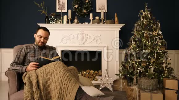 一个男人在圣诞节晚上对着相机看书的肖像视频的预览图
