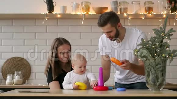 家庭假日和人的概念快乐的母亲父亲和小女儿在玩环形金字塔婴儿玩具视频的预览图