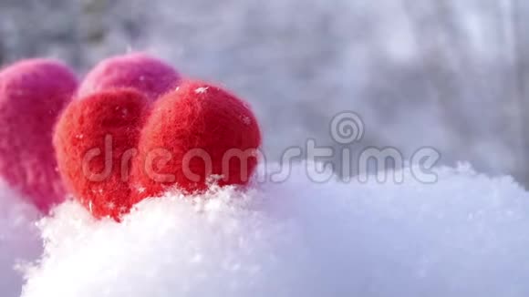 两颗情人节的羊毛心在冬天洁白的雪上慢动作视频的预览图