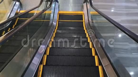 一个人在自动扶梯下楼梯的POV用黄线清空现代自动扶梯视频的预览图