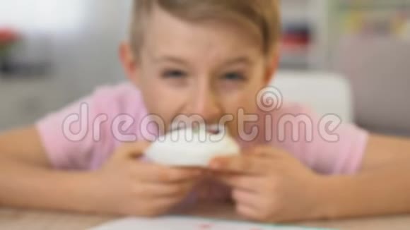 快乐男孩吃美味的奶油蛋糕不健康的营养龋齿风险关闭视频的预览图