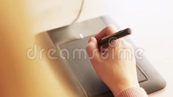女平面设计师用交互式笔显数字绘图平板和笔在电脑上手工特写视频的预览图