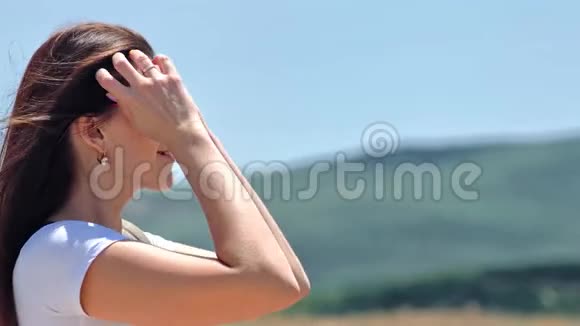 在温暖的夏日欣赏迷人的山景的白种人年轻女性形象视频的预览图