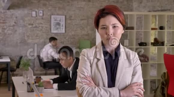 年轻的商业亚洲女性双手交叉在现代办公室里看着镜头严肃而关心黑色视频的预览图