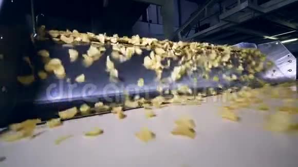 油炸薯片在食品厂的现代输送机上运输慢动作视频的预览图