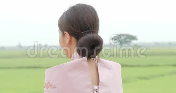 穿着传统东南亚服装的迷人的亚洲女人头转向镜头在一个背景上微笑视频的预览图