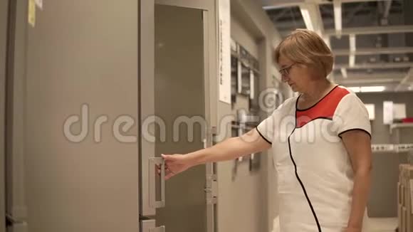 一个成年女人检查冰箱服务员打开衣柜门视频的预览图