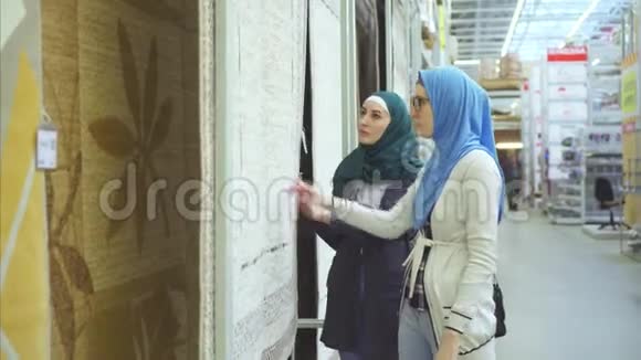 两个阿拉伯年轻女子选择地毯视频的预览图