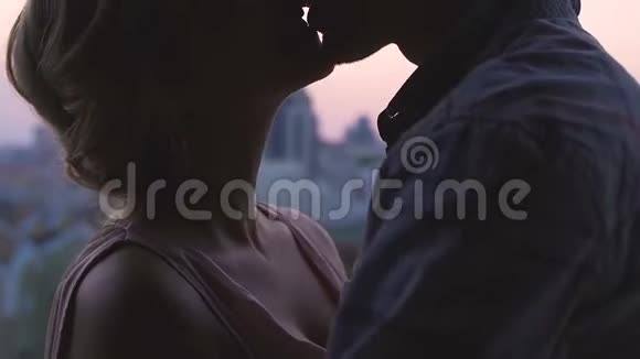男朋友和女朋友在日出时拥抱和亲吻在大城市约会爱视频的预览图