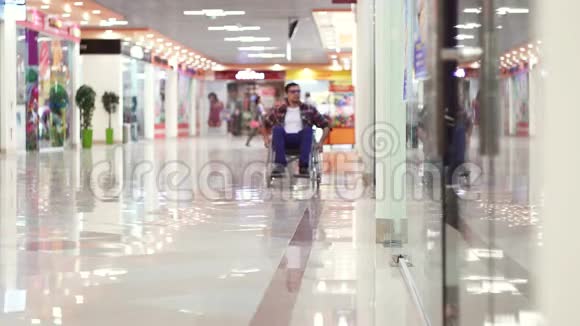 残疾人坐轮椅到购物中心看窗户视频的预览图