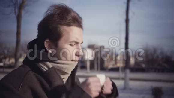 一个在寒冷的冬天用纸巾吹着的小男孩视频的预览图