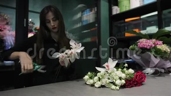 职业女性花店工作剪兰花白玫瑰和红玫瑰视频的预览图