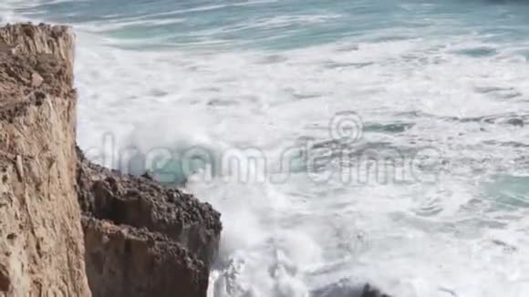 波浪在岩石上跳动从海面上的悬崖俯瞰视频的预览图