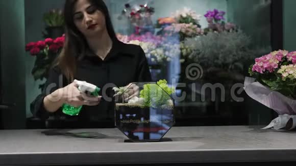 女子花艺师在花艺馆用水草喷洒视频的预览图