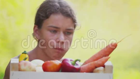 带着一盒新鲜的天然蔬菜的青少年男孩视频的预览图