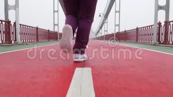 近距离拍摄一个穿着白色鞋子从摄像机里跑出来的女孩慢动作视频的预览图