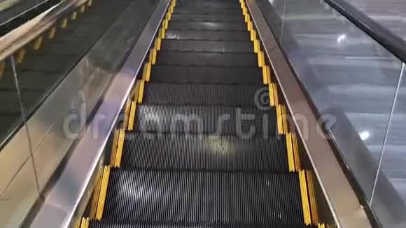 一个人在自动扶梯下楼梯的POV用黄线清空现代自动扶梯视频的预览图