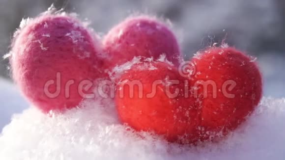 两颗情人节的羊毛心在冬天洁白的雪上慢动作视频的预览图