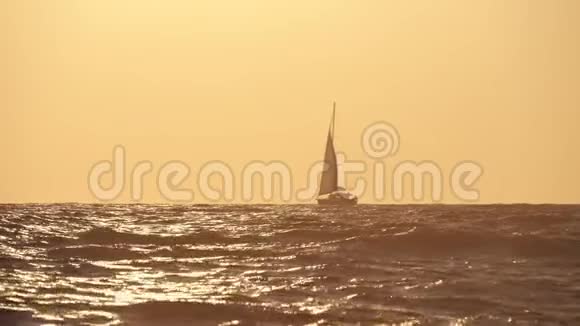 在日落的背景下航行游艇日落时分游艇在海洋中的轮廓游艇旅游浪漫之旅视频的预览图