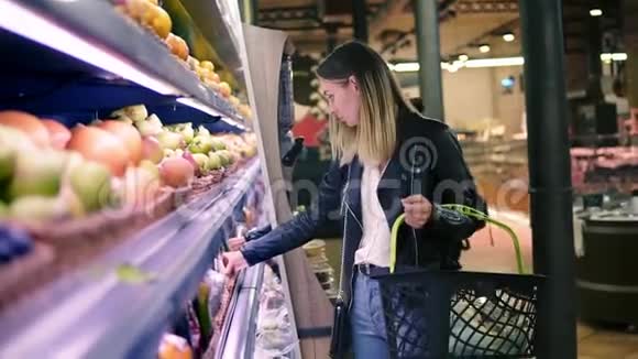 女人在超市里选择蔬菜金发美女在购物中心选择产品女孩站在附近视频的预览图