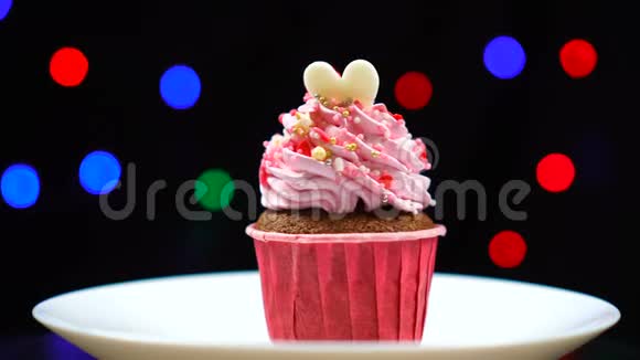 美味的纸杯蛋糕上面有甜草莓霜的漩涡在盘子上旋转视频的预览图